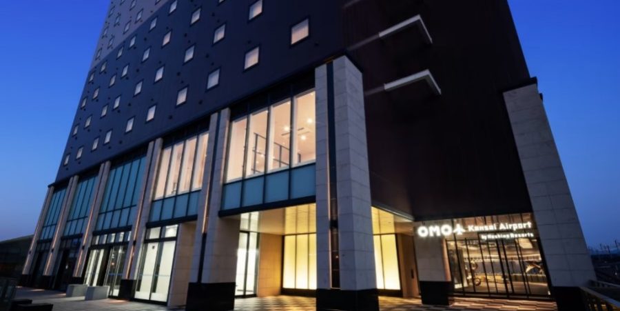 A hotel entrance with a prominent glass window and an eye-catching black and white checkered floor pattern.